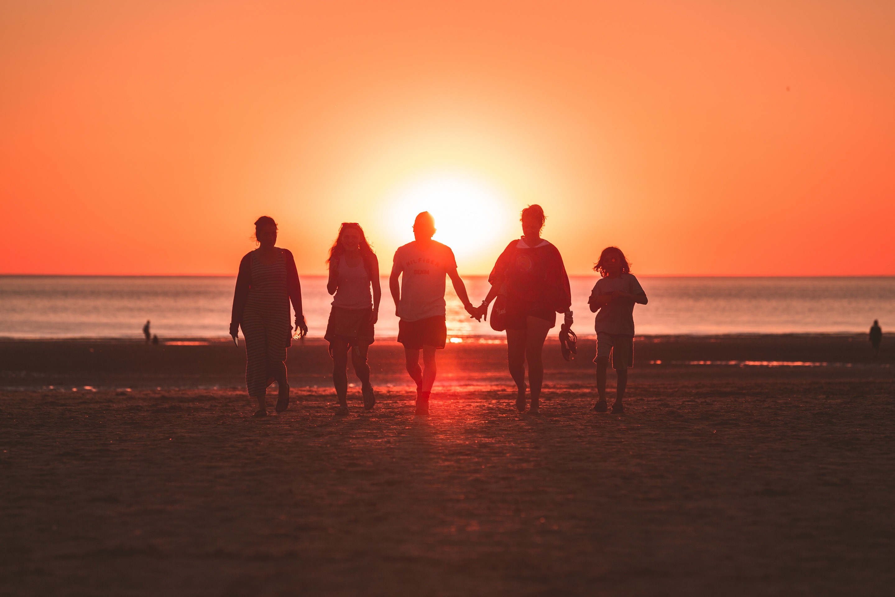 Family of 5 walking on the beach at sunset