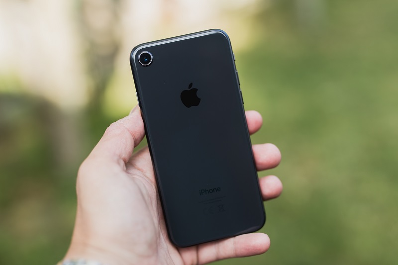 A parent holding an iPhone mobile device.